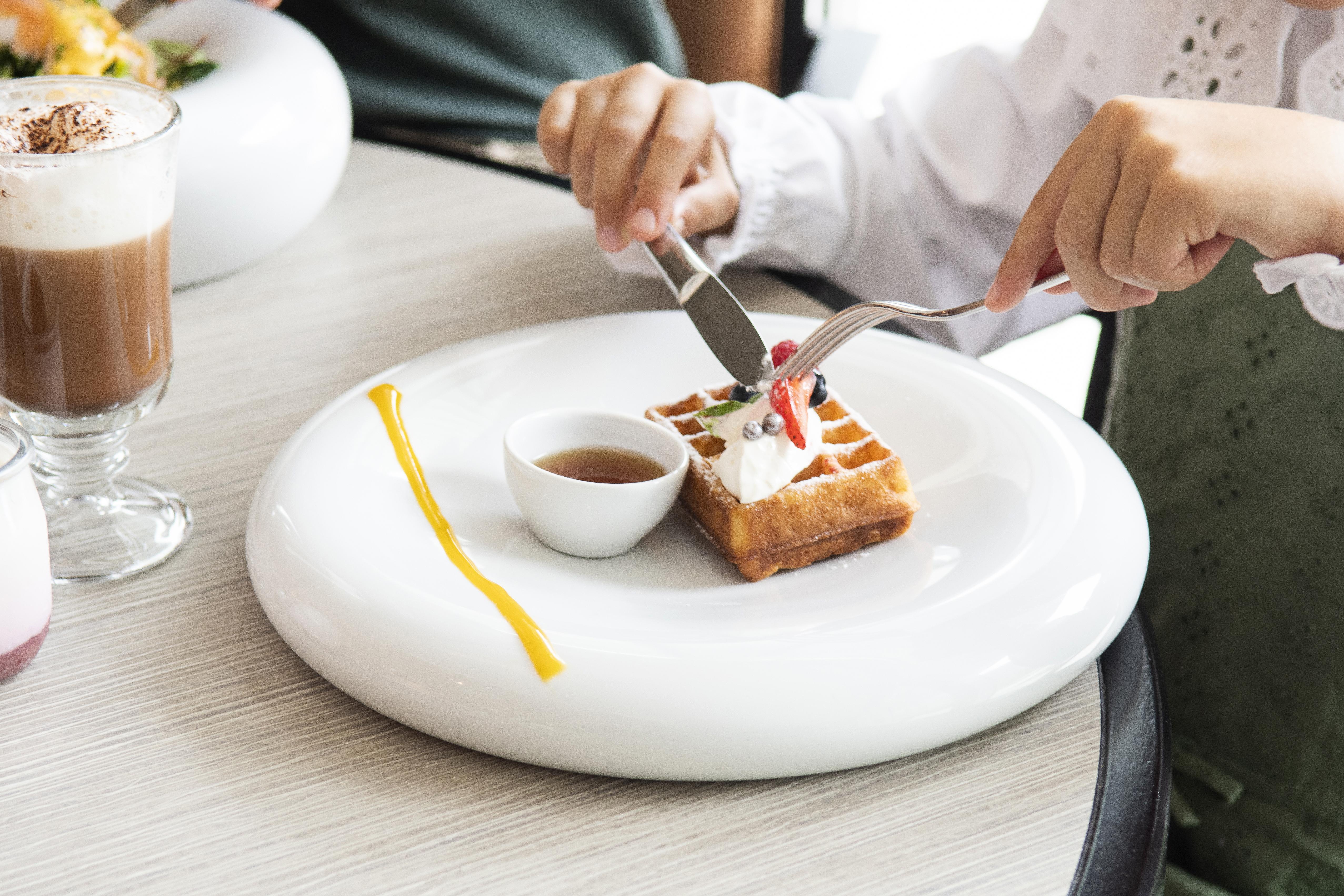 فندق إبيك سانا لشبونه Lisboa المظهر الخارجي الصورة A woman using a knife and fork to cut a dessert